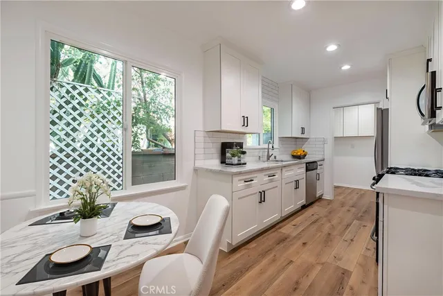 a kitchen with a white cabinets and chairs