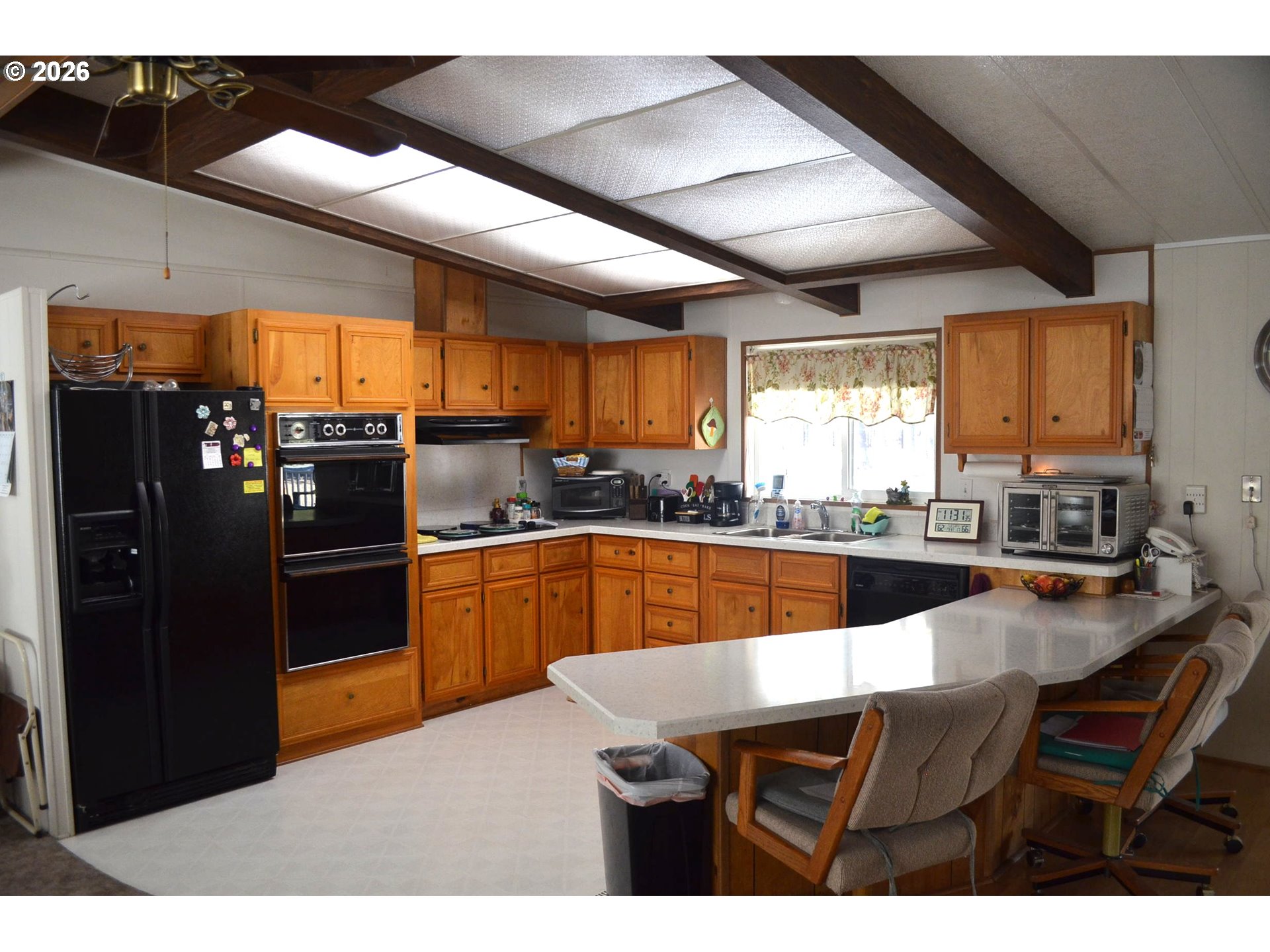 244 Kaehn Road Crescent, OR 97733 - Photo 6 of 47 a kitchen with stainless steel appliances granite countertop a refrigerator a sink dishwasher a stove and black cabinets with wooden floor