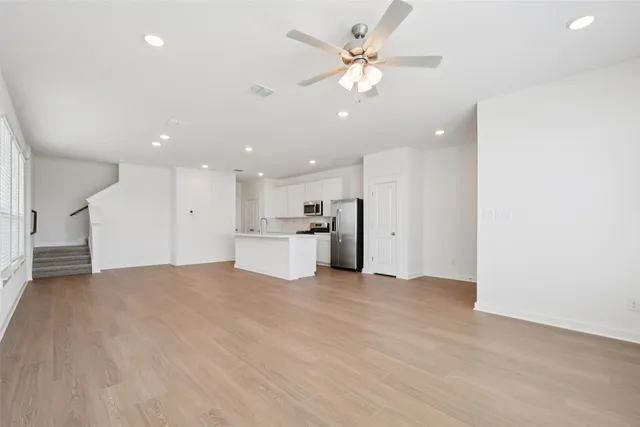 a view of an empty room with a kitchen