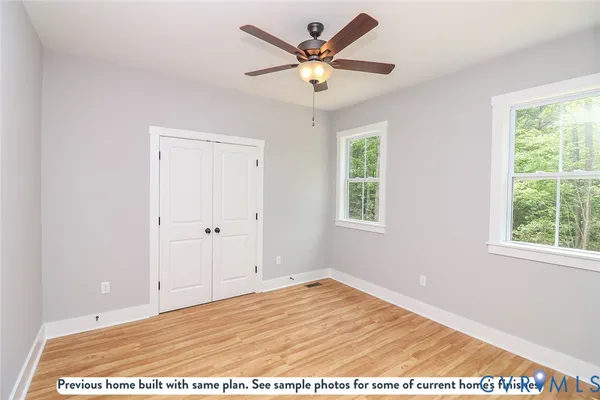 a bathroom with a granite countertop sink a toilet a mirror and a window
