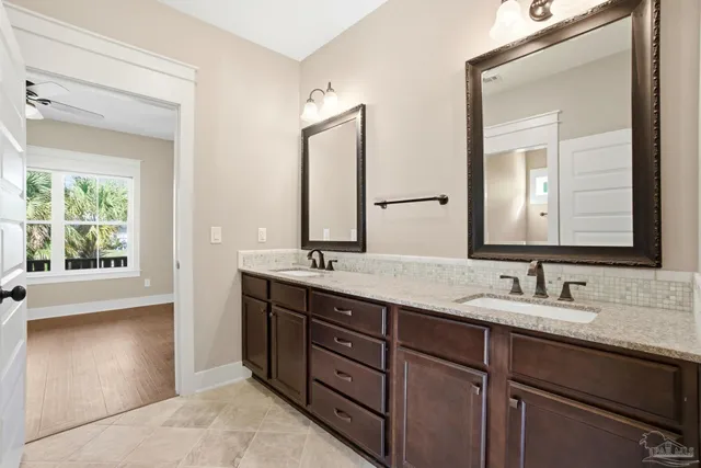 a bathroom with a granite countertop sink double and mirror