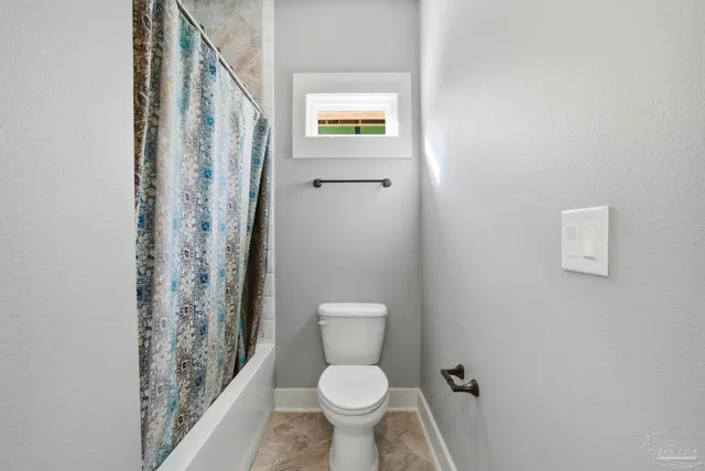 a white toilet sitting next to a small bathroom