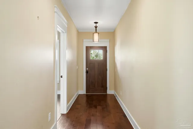 a view of a hallway with wooden floor and staircase