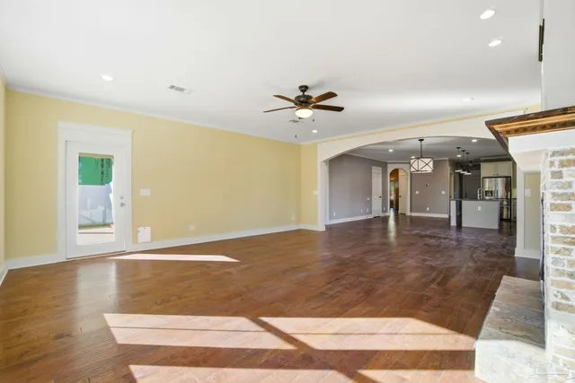 a view of a room with wooden floor and ceiling fan