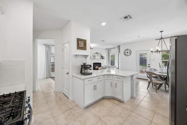 a kitchen with a sink and chairs