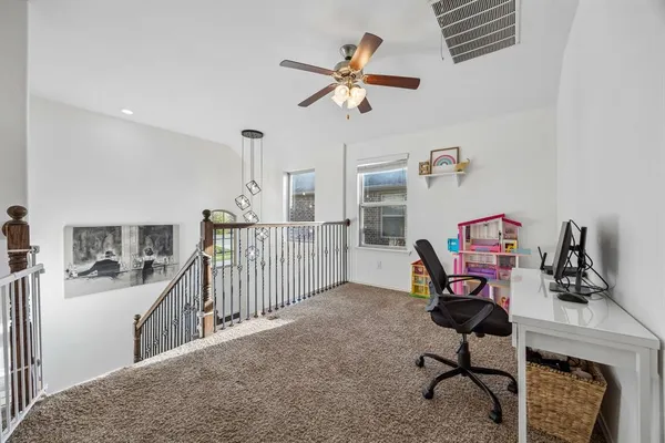 a view of a workspace with furniture and a ceiling fan