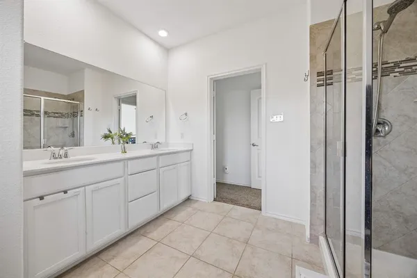 a spacious bathroom with a shower sink and mirror