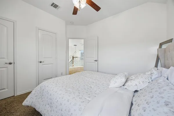 a bedroom with a bed and a chandelier fan