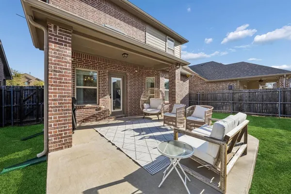 a view of a patio with table and chairs with wooden floor and fence