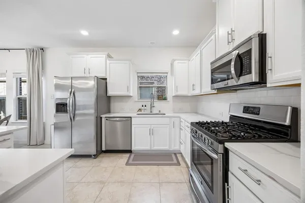 a kitchen with stainless steel appliances granite countertop a stove a refrigerator and a microwave