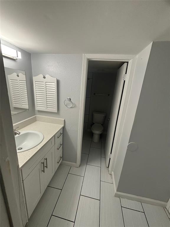 301 Rolston Road, Unit 317103 Irving, TX 75060 - Photo 7 of 9 Bathroom featuring a white vanity with an undermount sink, a light-colored countertop, and white cabinetry with silver hardware