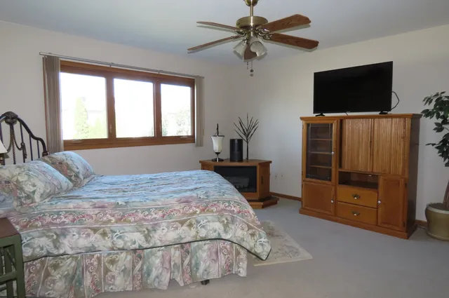 a bedroom with a bed and a ceiling fan