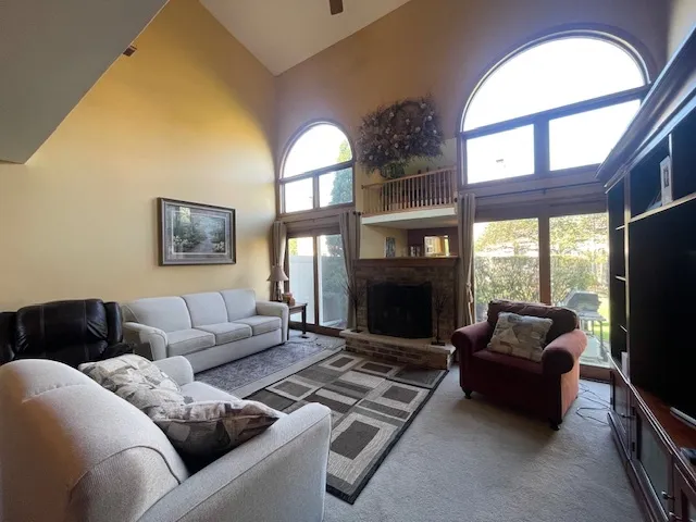 a living room with furniture a fireplace and a large window
