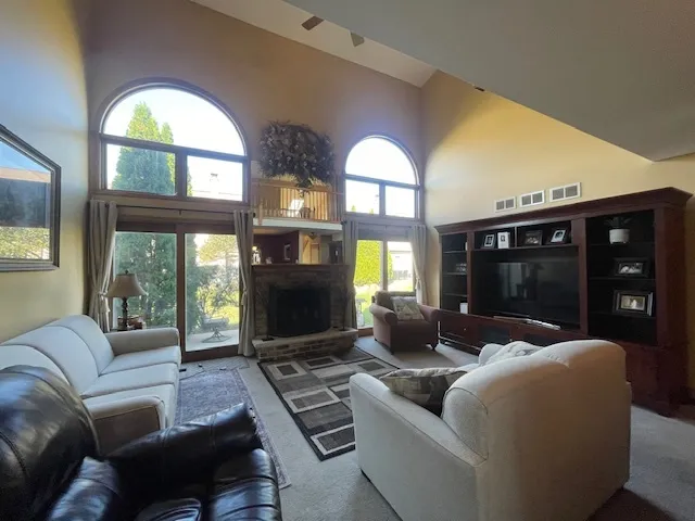 a living room with furniture a floor to ceiling window and a flat screen tv