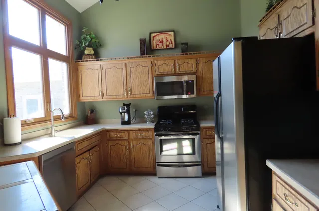 a kitchen with stainless steel appliances granite countertop a refrigerator and a sink