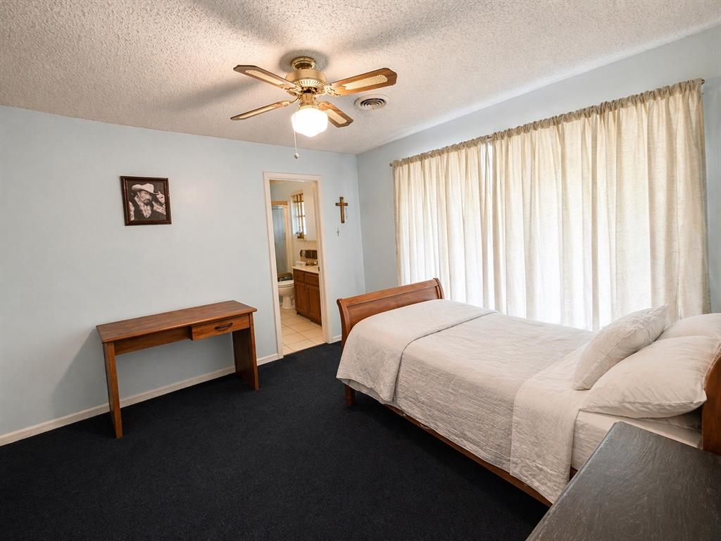 504 Aspen Road Gainesville, TX 76240 - Photo 10 of 11 a bedroom with a bed and a chandelier
