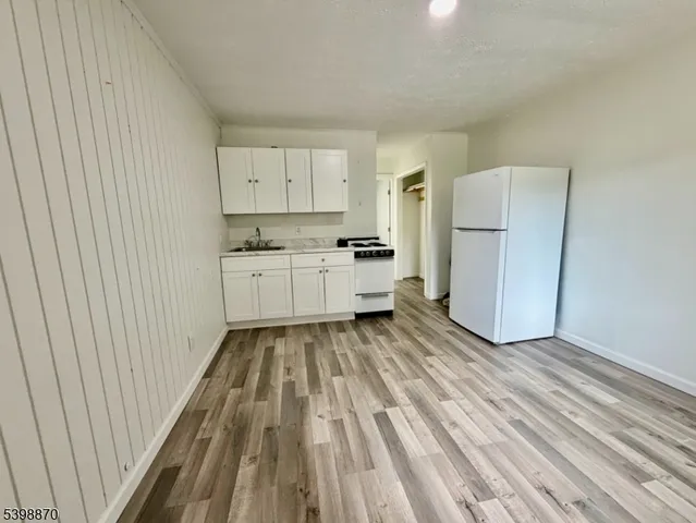 a kitchen with a refrigerator and white cabinets