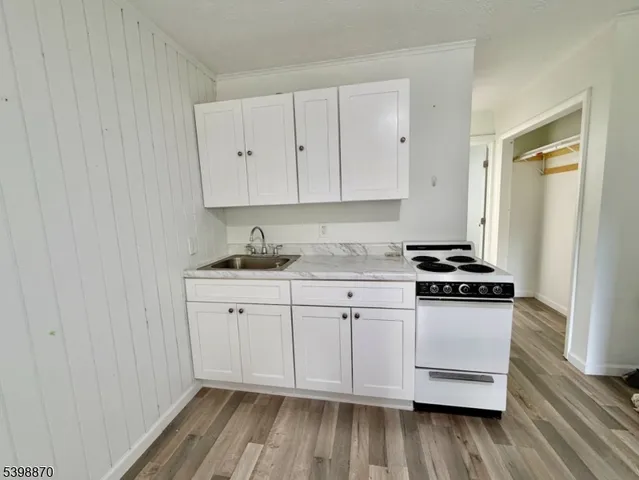 a kitchen with granite countertop white cabinets and white appliances