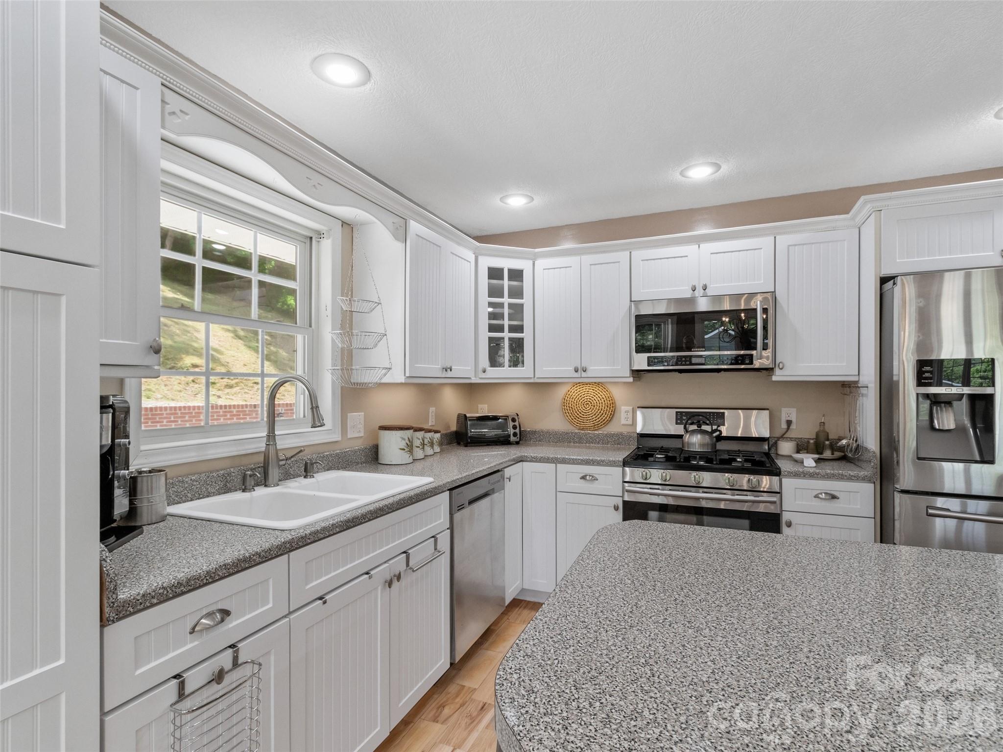 189 Poverty Branch Road Barnardsville, NC 28709 - Photo 11 of 48 a kitchen with stainless steel appliances granite countertop a stove sink and cabinets