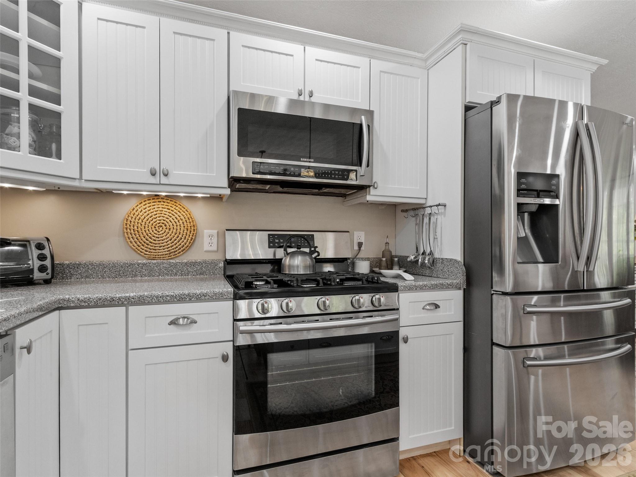 189 Poverty Branch Road Barnardsville, NC 28709 - Photo 12 of 48 a kitchen with stainless steel appliances granite countertop a stove microwave and refrigerator