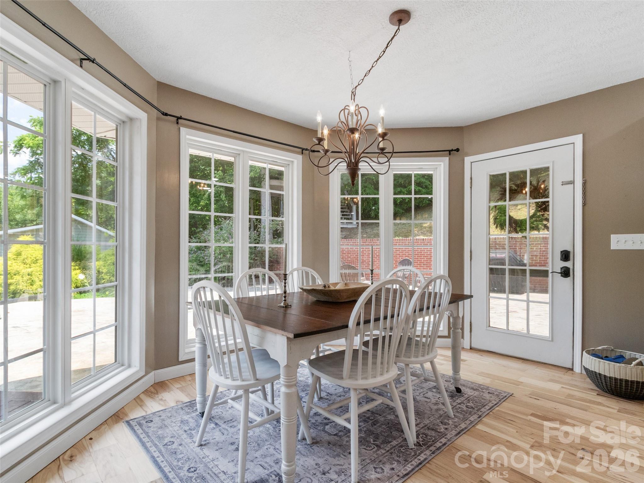 189 Poverty Branch Road Barnardsville, NC 28709 - Photo 16 of 48 a dining room with furniture a chandelier and wooden floor