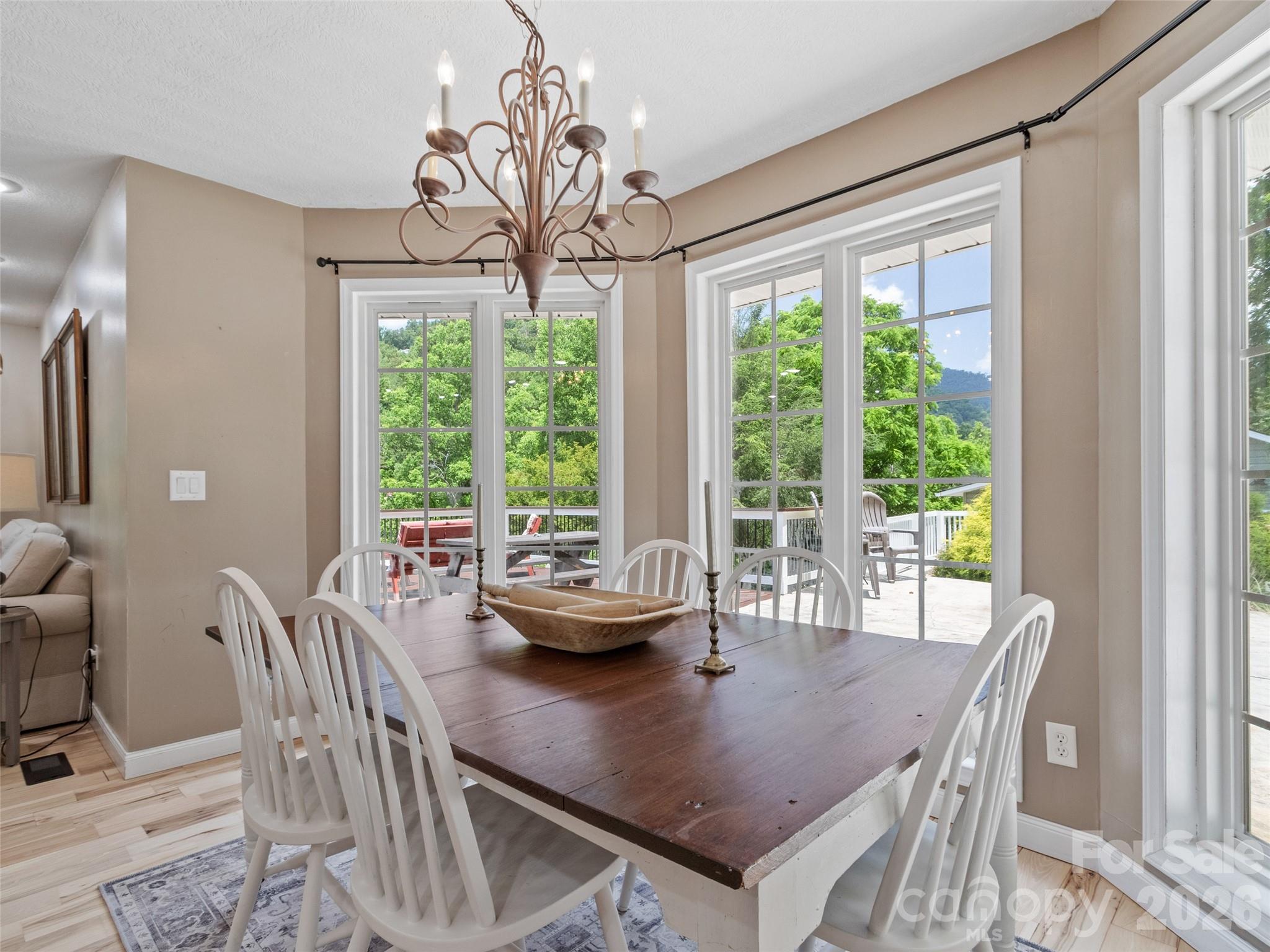 189 Poverty Branch Road Barnardsville, NC 28709 - Photo 17 of 48 a dining room with furniture a chandelier and wooden floor