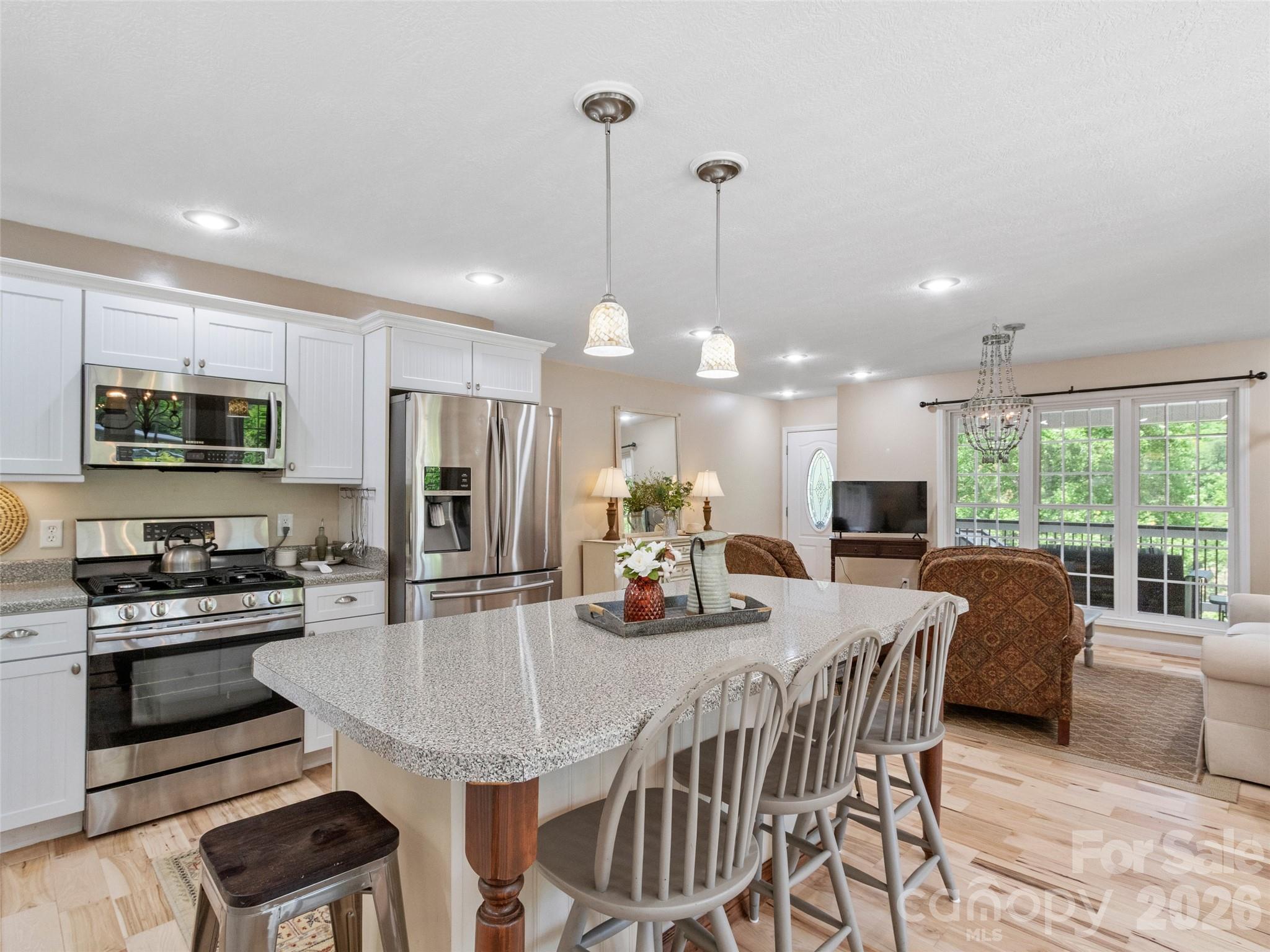 189 Poverty Branch Road Barnardsville, NC 28709 - Photo 9 of 48 a kitchen with stainless steel appliances granite countertop a stove a refrigerator a kitchen island a dining table and chairs