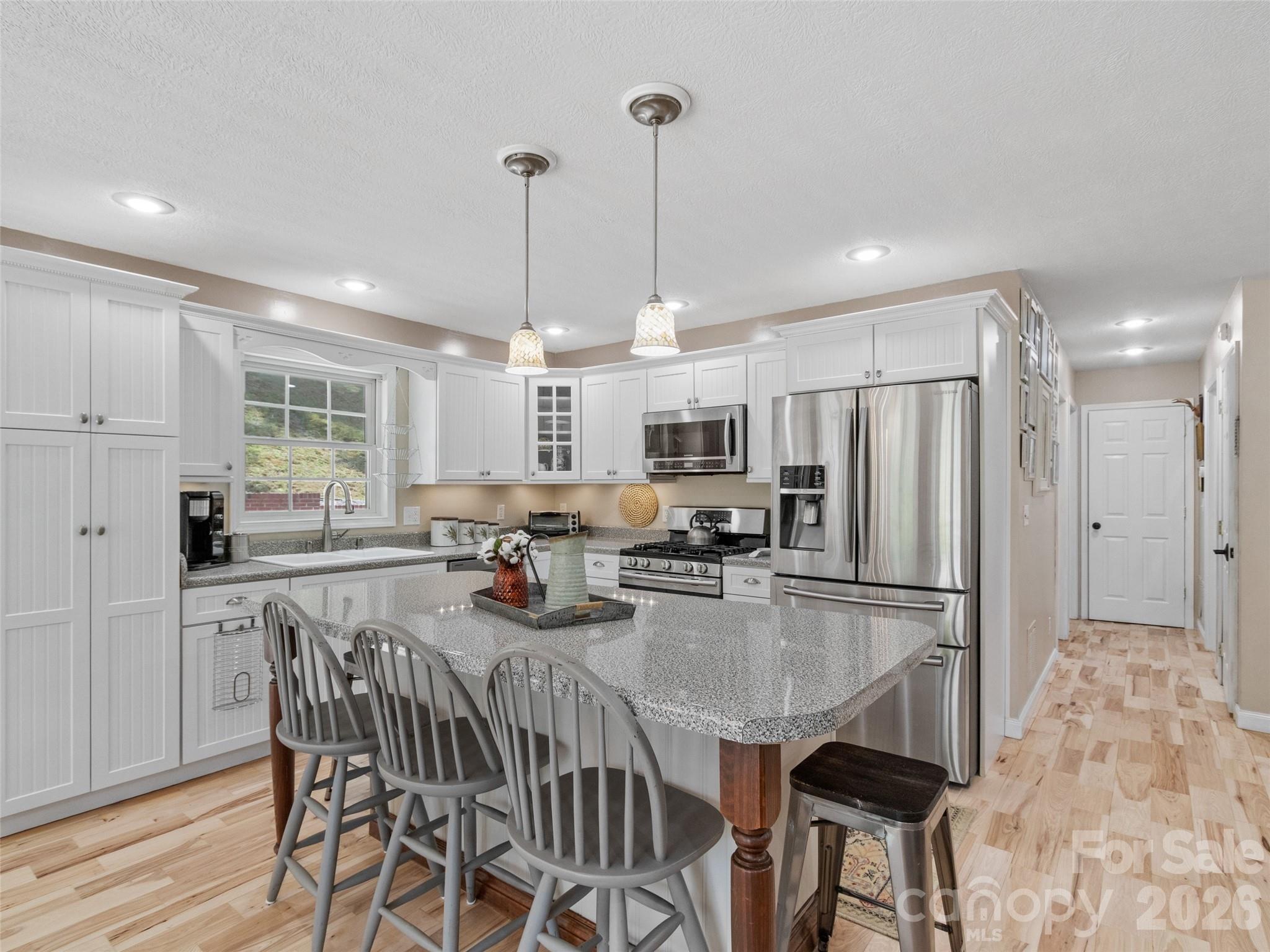 189 Poverty Branch Road Barnardsville, NC 28709 - Photo 10 of 48 a kitchen with stainless steel appliances granite countertop a dining table chairs stove refrigerator and cabinets