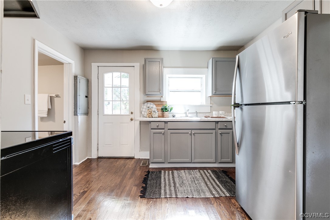 5436 Snead Road Richmond, VA 23224 - Photo 10 of 22 a kitchen with a refrigerator a sink and wooden floor