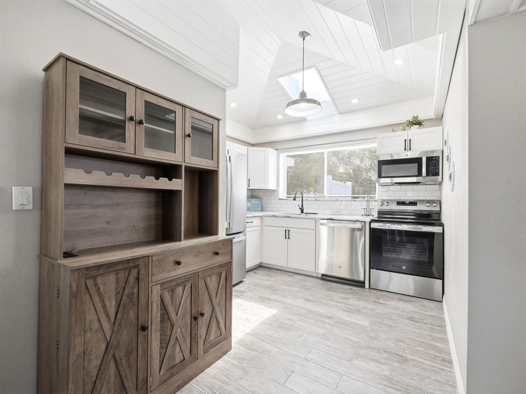 1207 1st Street Indian Rocks Beach, FL 33785 - Photo 12 of 60 a kitchen with stainless steel appliances a stove a microwave and a refrigerator