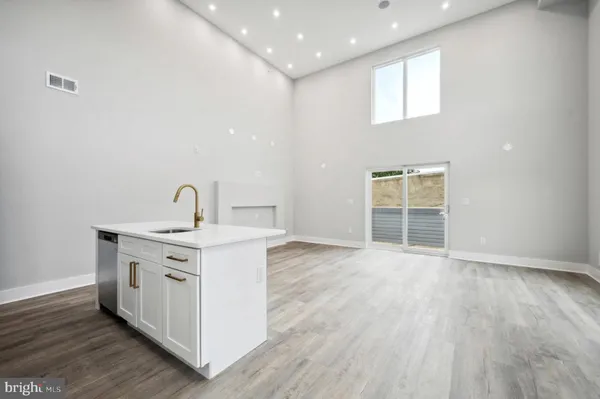 a view of a kitchen with a sink wooden floor and windows