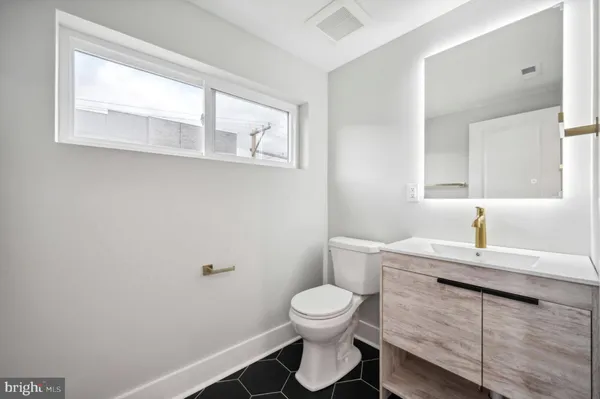 a bathroom with a toilet sink and mirror
