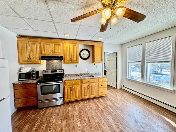 a kitchen with stainless steel appliances granite countertop a stove a sink and a microwave