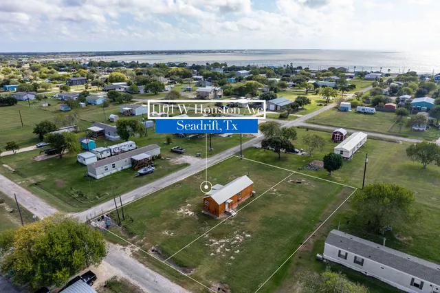 an aerial view of a tennis ground and a cars park side of the road