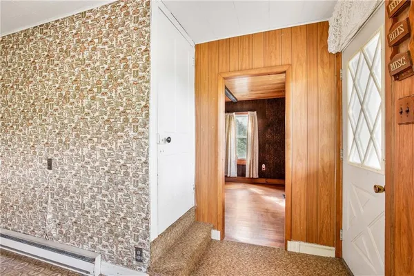 a view of a hallway with wooden floor and a door