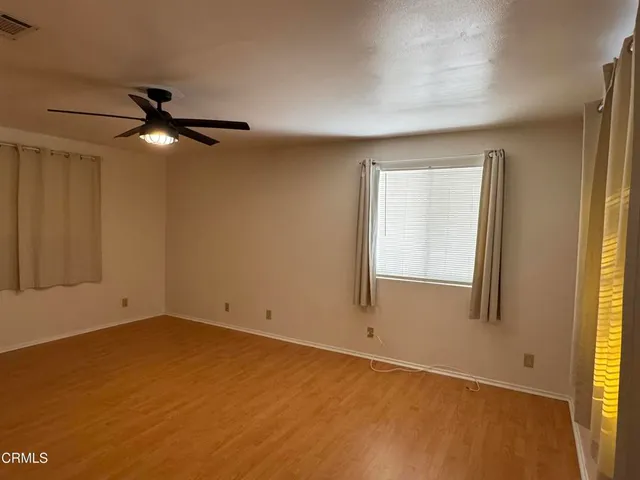 an empty room with a window and a ceiling fan