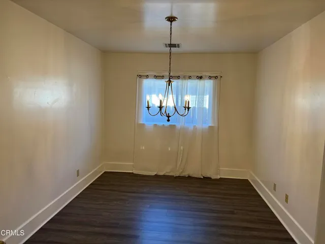 a room with wooden floor and chandelier