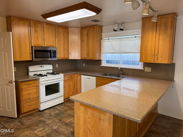 a kitchen with a stove a sink and a microwave