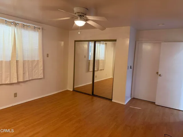 an empty room with fan and windows