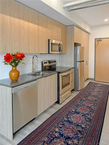 a kitchen with stainless steel appliances granite countertop a sink stove and refrigerator