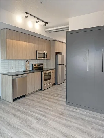 a kitchen with stainless steel appliances granite countertop a refrigerator and a stove top oven