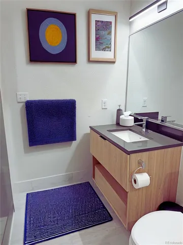 a bathroom with a sink mirror vanity and toilet