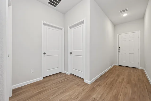 a view of an empty room with wooden floor