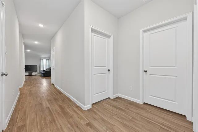 a view of a hallway with wooden floor and staircase