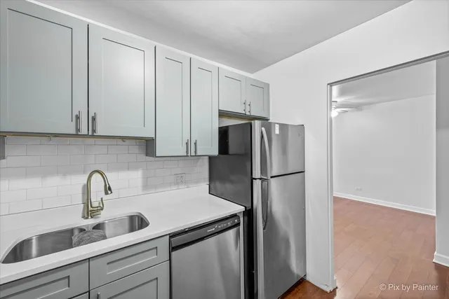 a kitchen with refrigerator a sink and cabinets