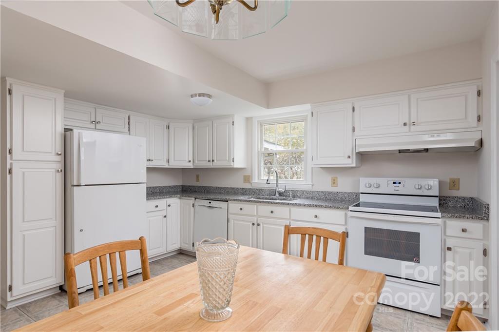 6777 Stoney Ridge Road Matthews, NC 28104 - Photo 12 of 27 a kitchen with stainless steel appliances granite countertop a stove a sink dishwasher a refrigerator white cabinets and wooden floor