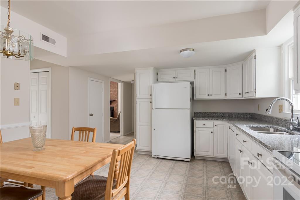 6777 Stoney Ridge Road Matthews, NC 28104 - Photo 10 of 27 a kitchen with granite countertop a refrigerator a stove a sink and white cabinets