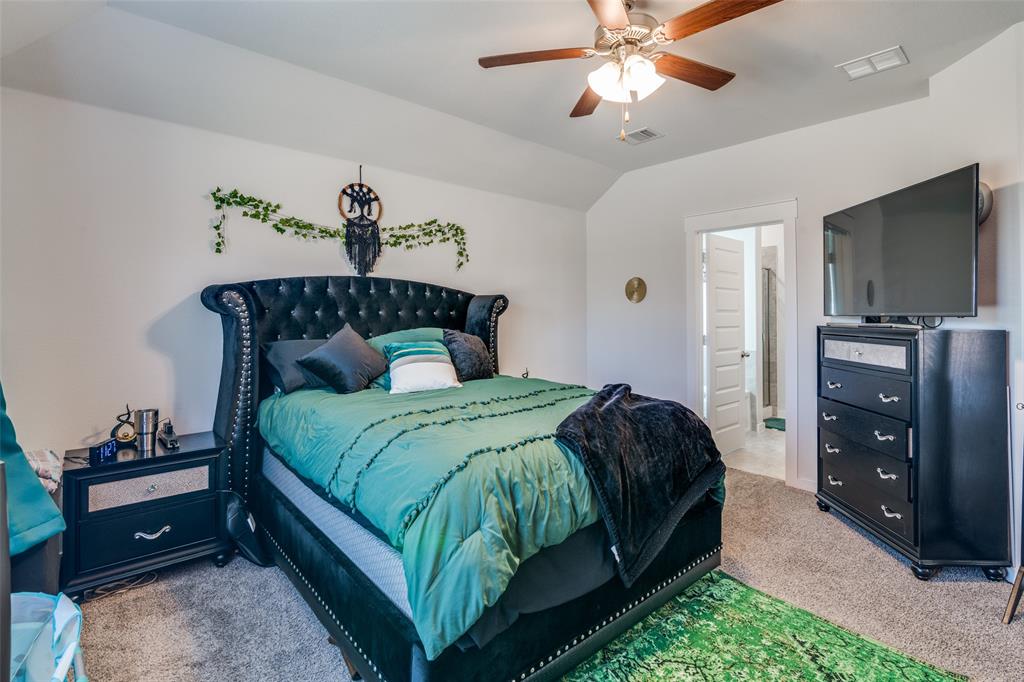 4204 Bullock Lane Forney, TX 75126 - Photo 19 of 25 a bedroom with a bed and a chandelier