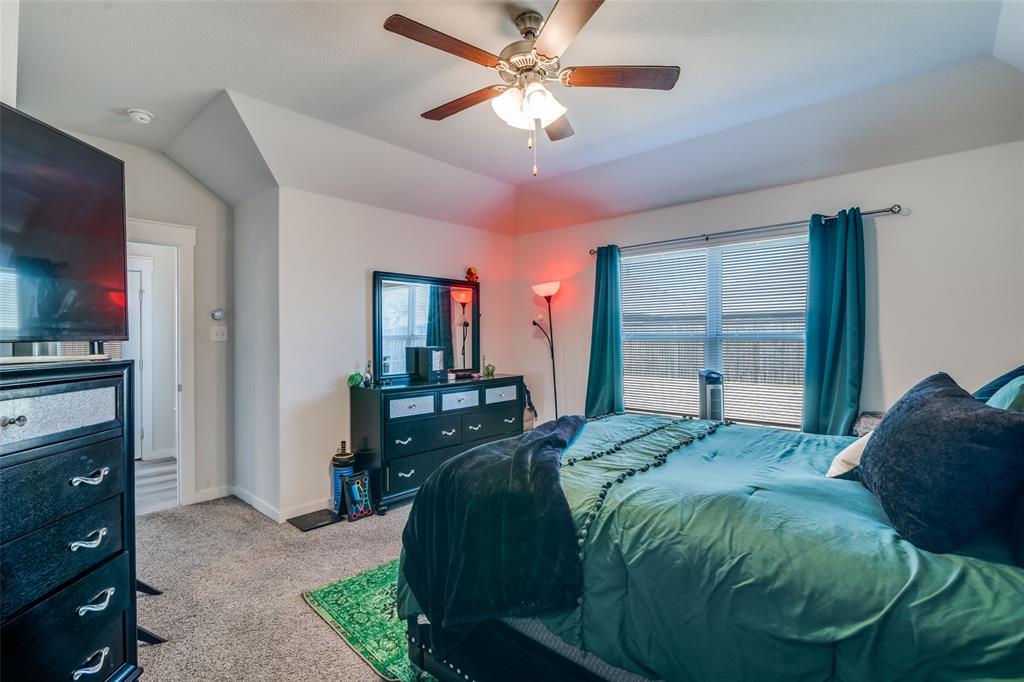 4204 Bullock Lane Forney, TX 75126 - Photo 20 of 25 a bedroom with a bed and a flat tv screen on dresser