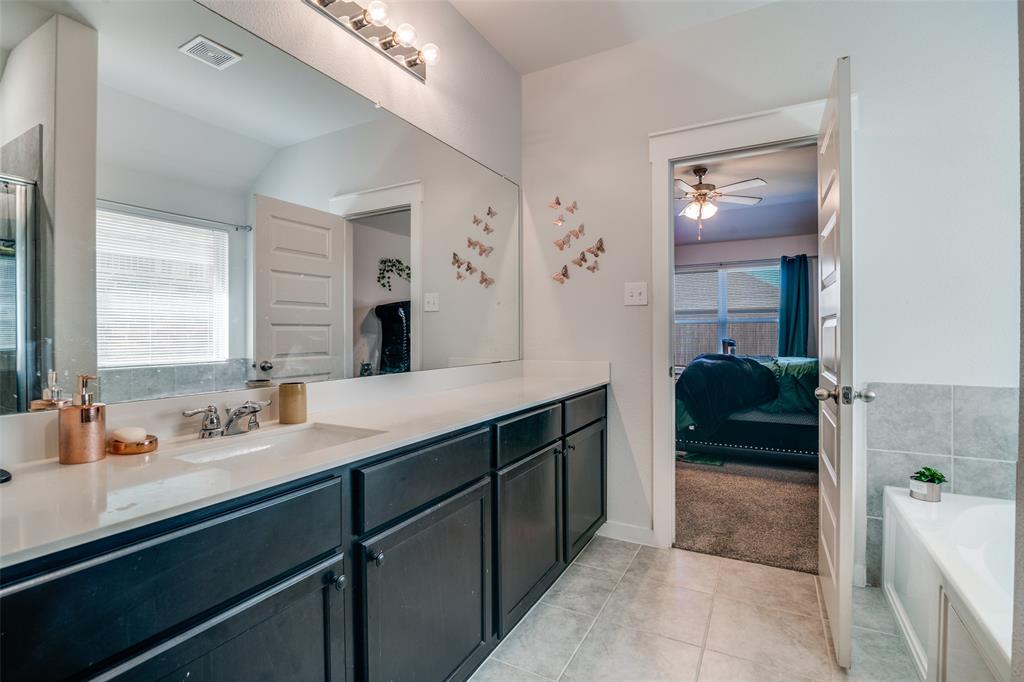 4204 Bullock Lane Forney, TX 75126 - Photo 23 of 25 a en suite bathroom with a double vanity sink and a mirror